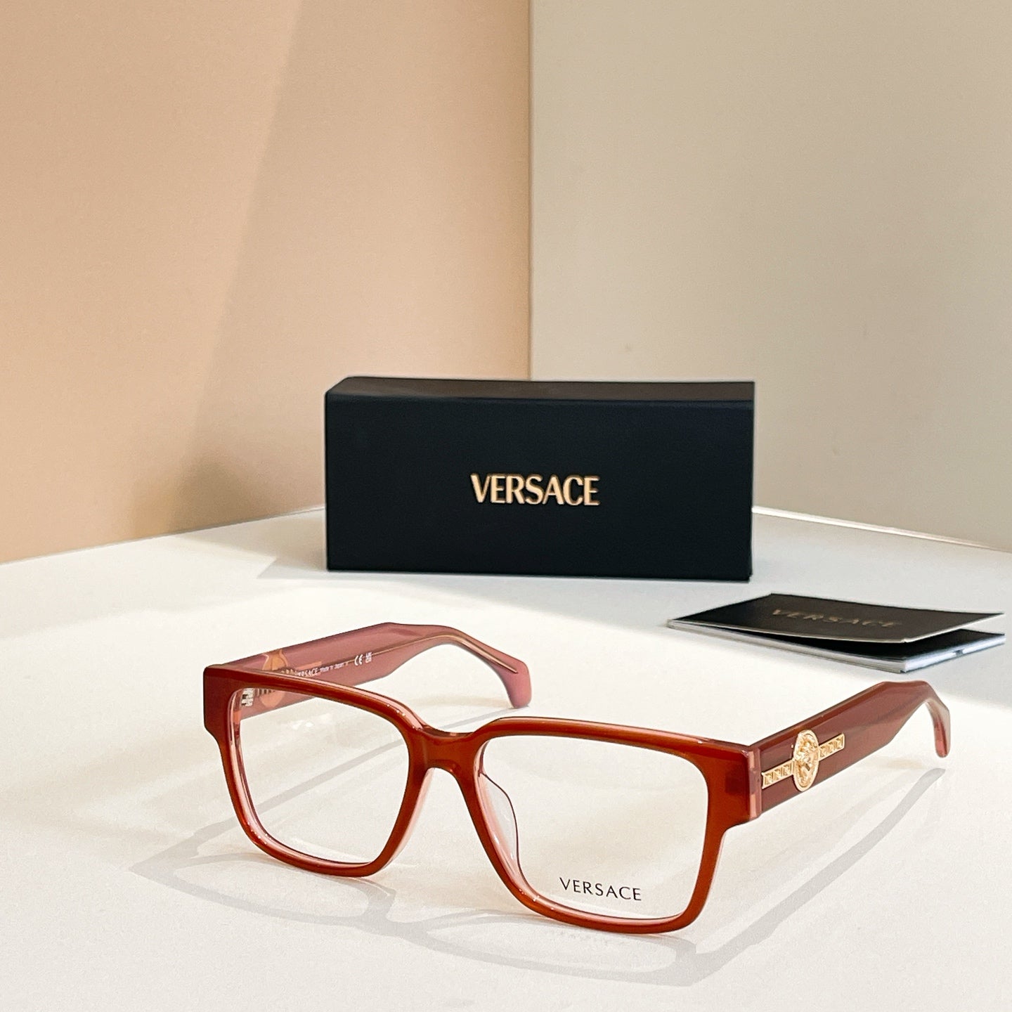 Versace glasses with red square frames and gold emblem on temple arms