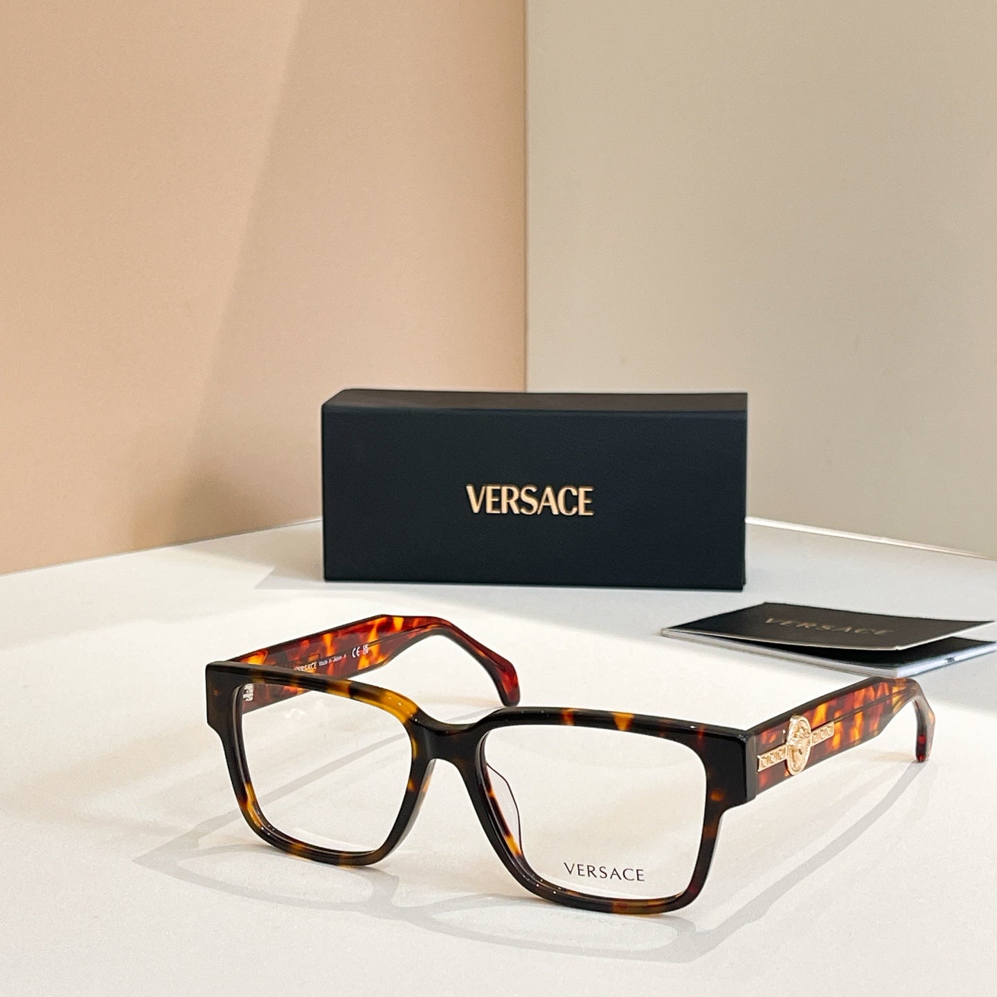 Versace glasses with tortoiseshell square frames and gold emblem on temple arms