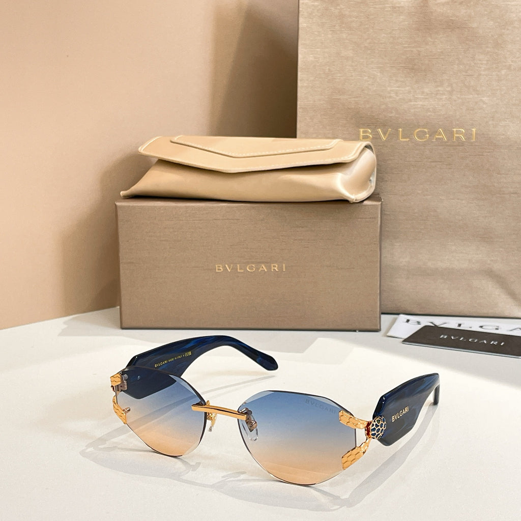 Blue-tinted gradient sunglasses with gold-tone frame and patterned temple accents