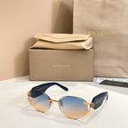 Blue-tinted gradient sunglasses with gold-tone frame and patterned temple accents