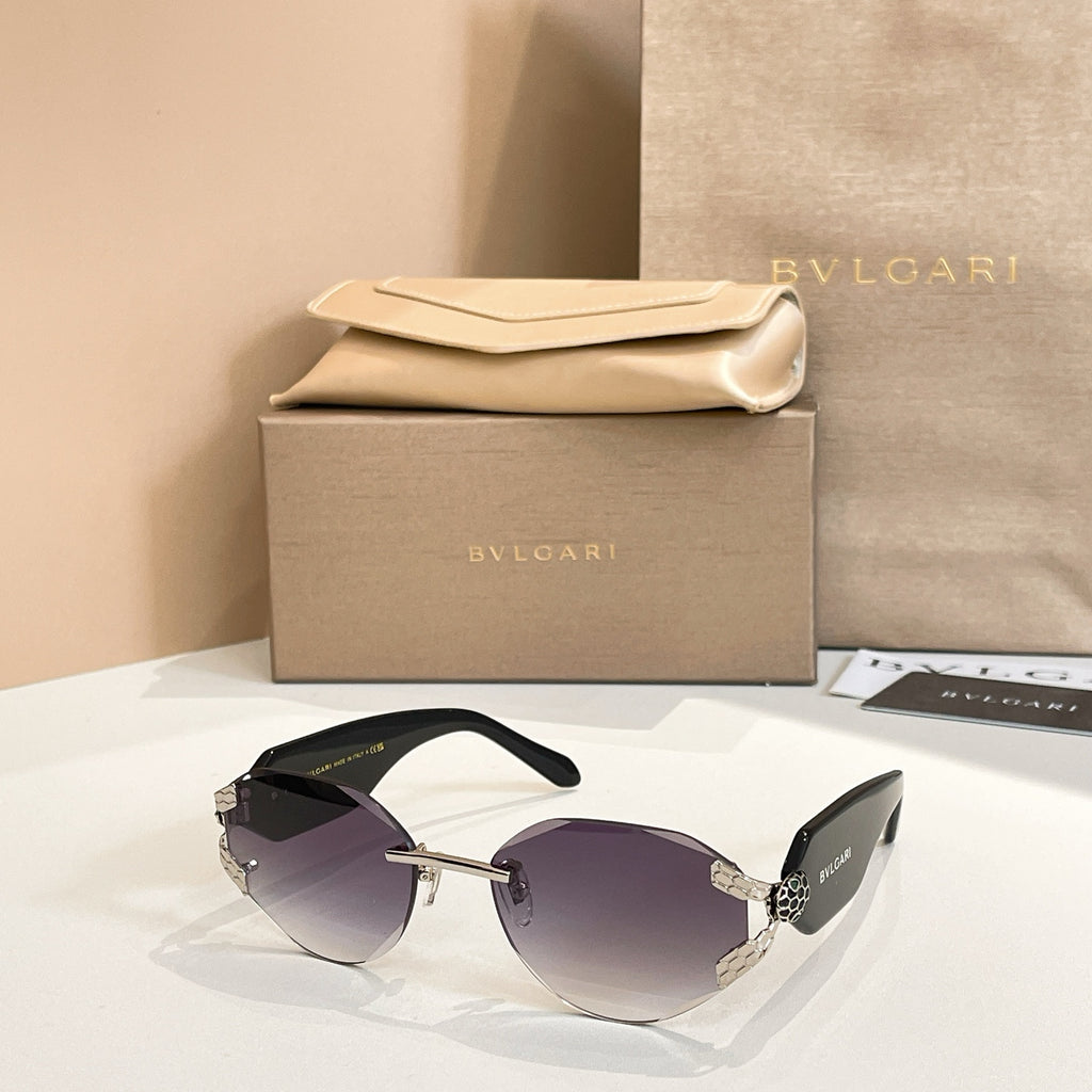 Dark-tinted sunglasses with gold-tone frame and patterned temple accents