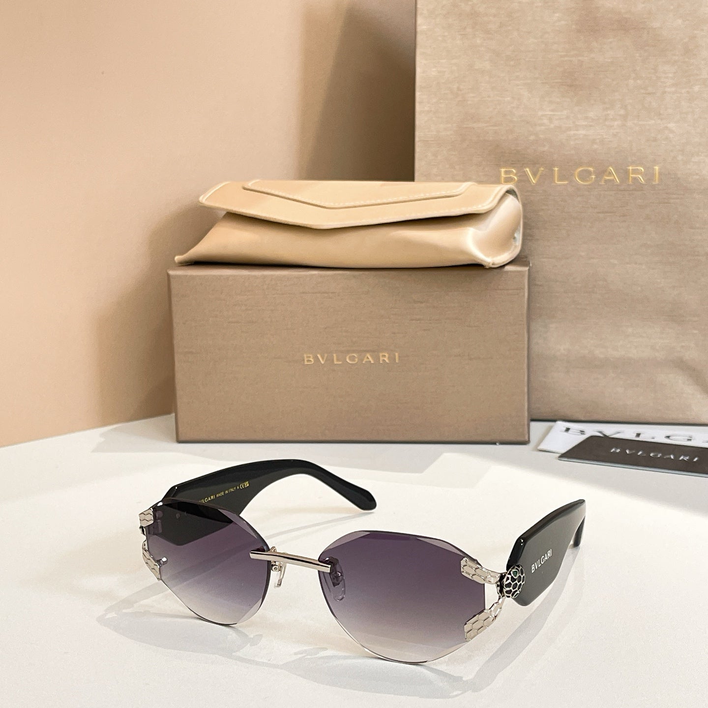 Dark-tinted sunglasses with gold-tone frame and patterned temple accents