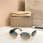 Green-tinted gradient sunglasses with gold-tone frame and decorative temple details