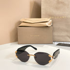 Black-tinted gradient sunglasses with gold-tone frame and patterned temple accents
