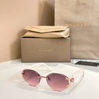 Pink-tinted gradient sunglasses with gold-tone frame and decorative temple details