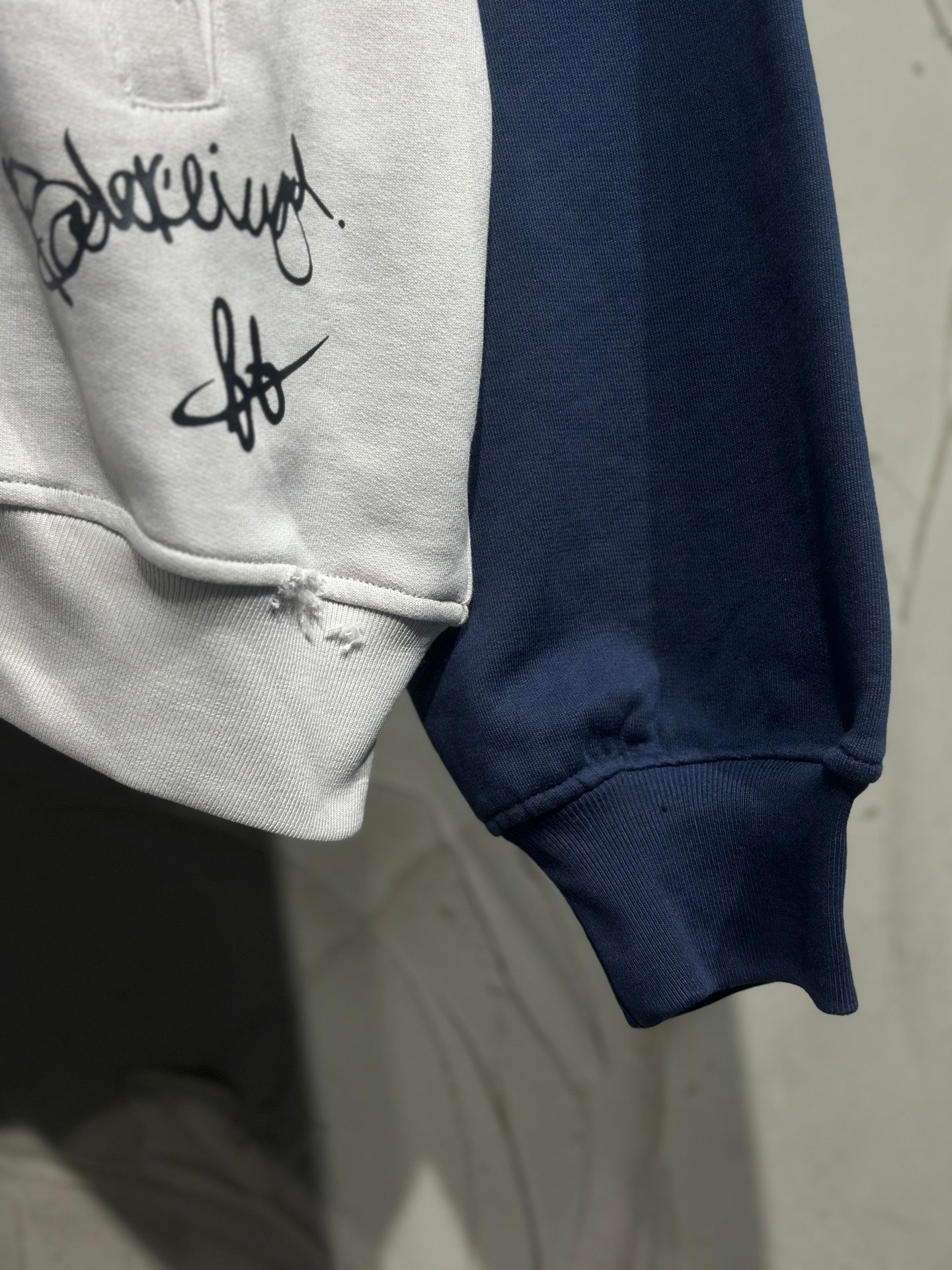 Hoodie sleeve cuff and chest graphic on light gray fabric