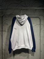 Pullover hoodie with white body, dark blue sleeves, and drawstring hood