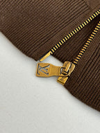 Brown ribbed cuff with gold zipper pull and engraved logo hardware