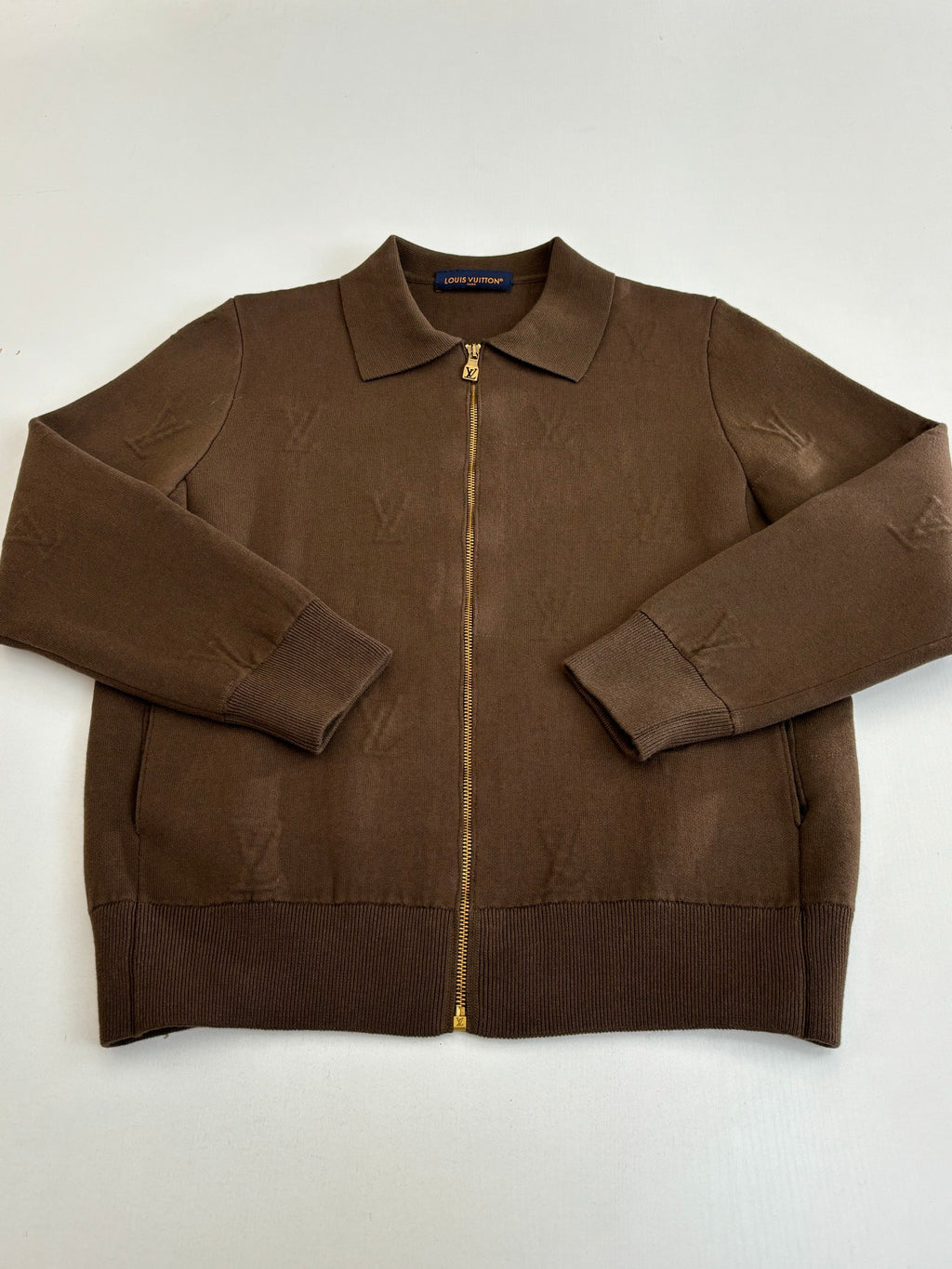 Brown long-sleeve zip-up jacket with stand collar, front zip, and pockets