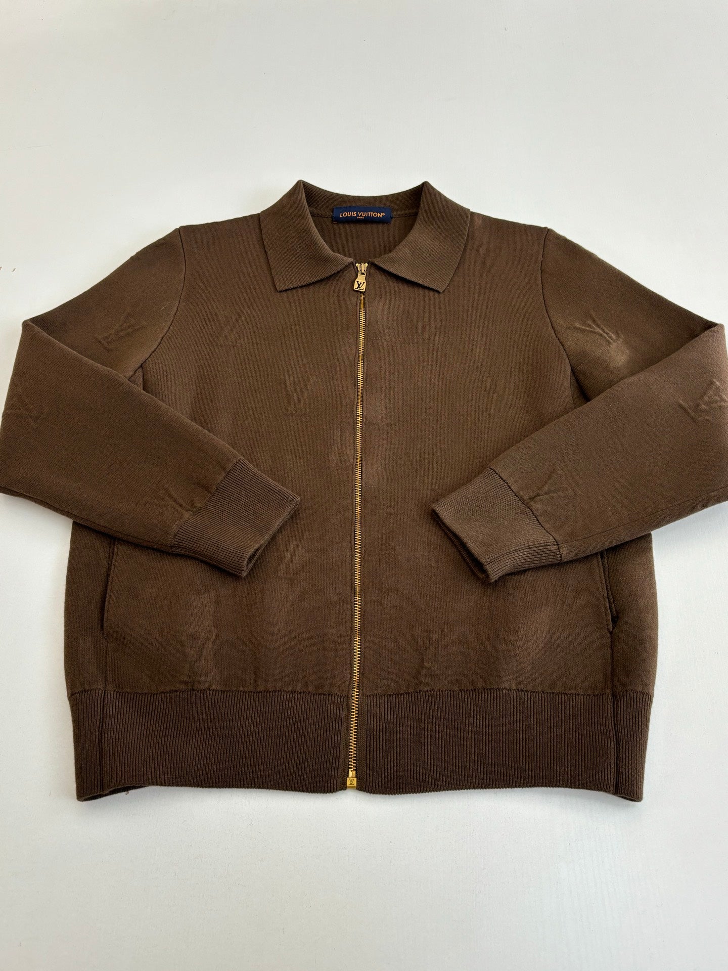 Brown long-sleeve zip-up jacket with stand collar, front zip, and pockets