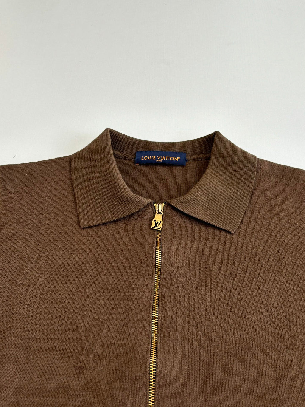 Brown zip-up jacket close-up with stand collar and gold Louis Vuitton zipper