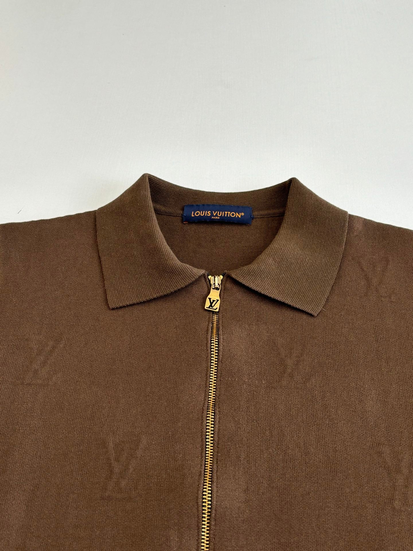Brown zip-up jacket close-up with stand collar and gold Louis Vuitton zipper