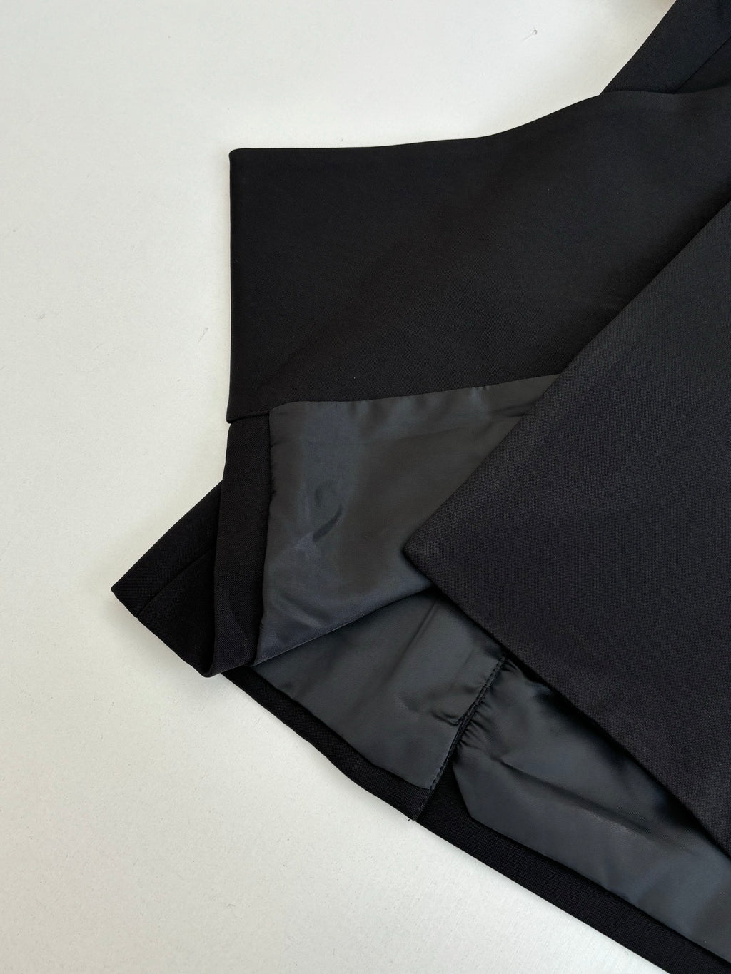 Black long trousers folded with dark lining visible