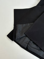 Black long trousers folded with dark lining visible