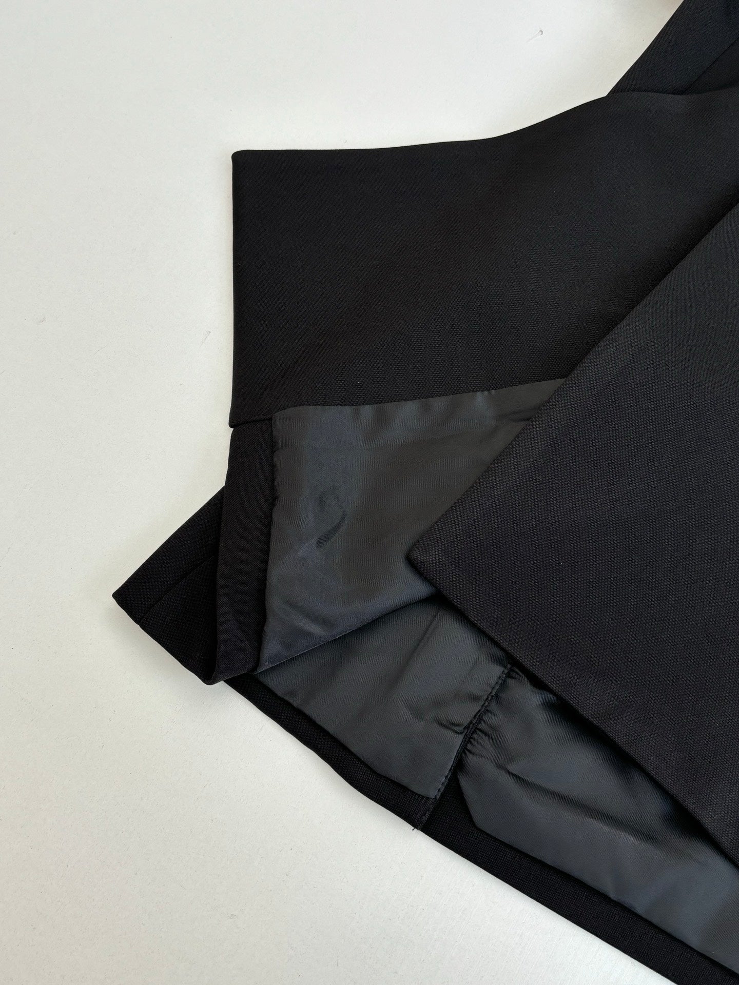 Black long trousers folded with dark lining visible