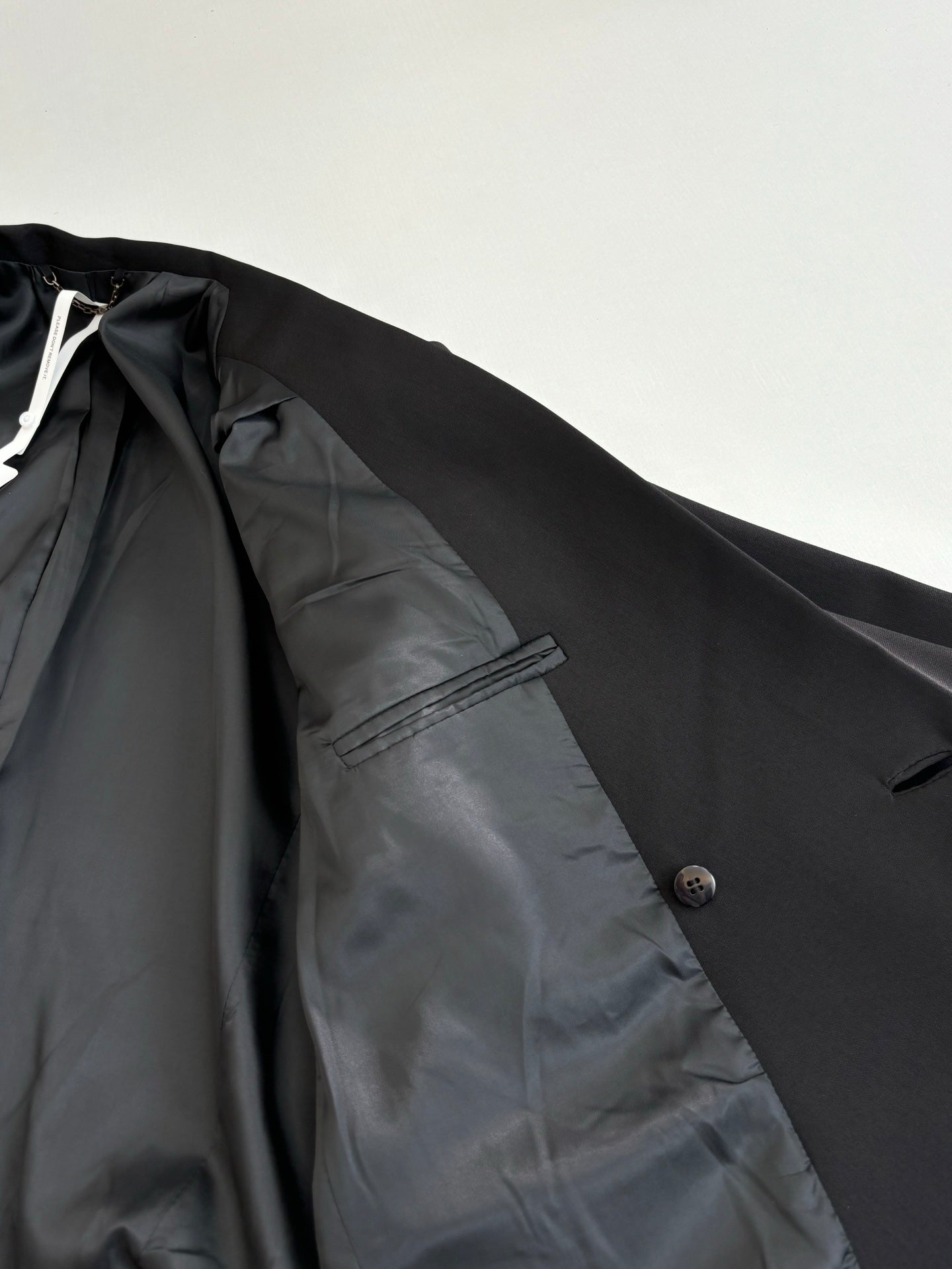 Black long blazer jacket inner lining and pocket close-up.