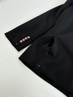 Black long blazer jacket sleeve cuff close-up with four buttons and stitched detail.