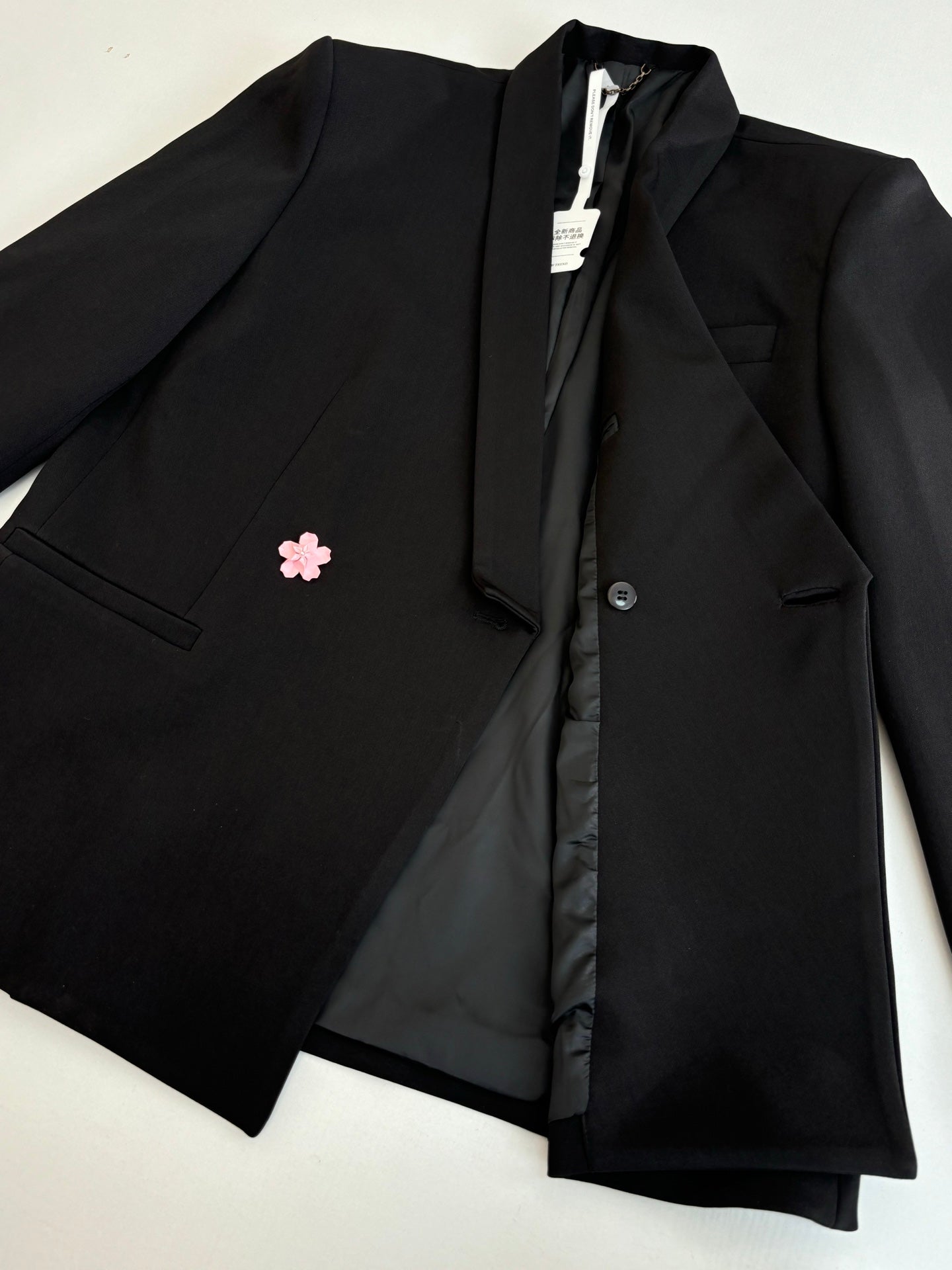 Black long blazer jacket folded open, showing lining and a center front button placket.