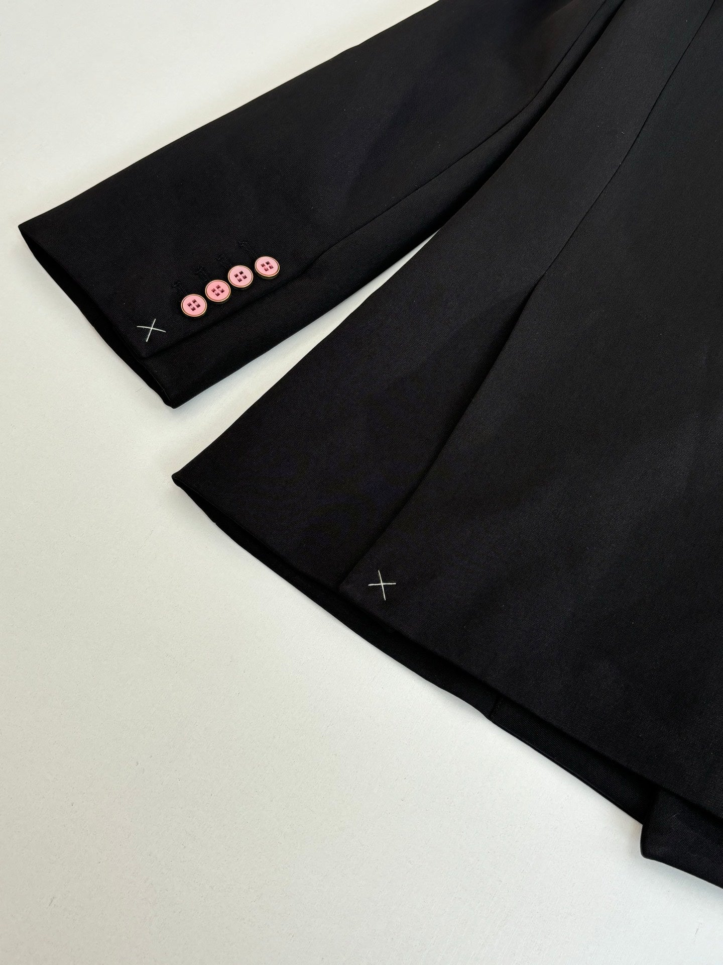 Black long trousers with pink button trim at cuffs