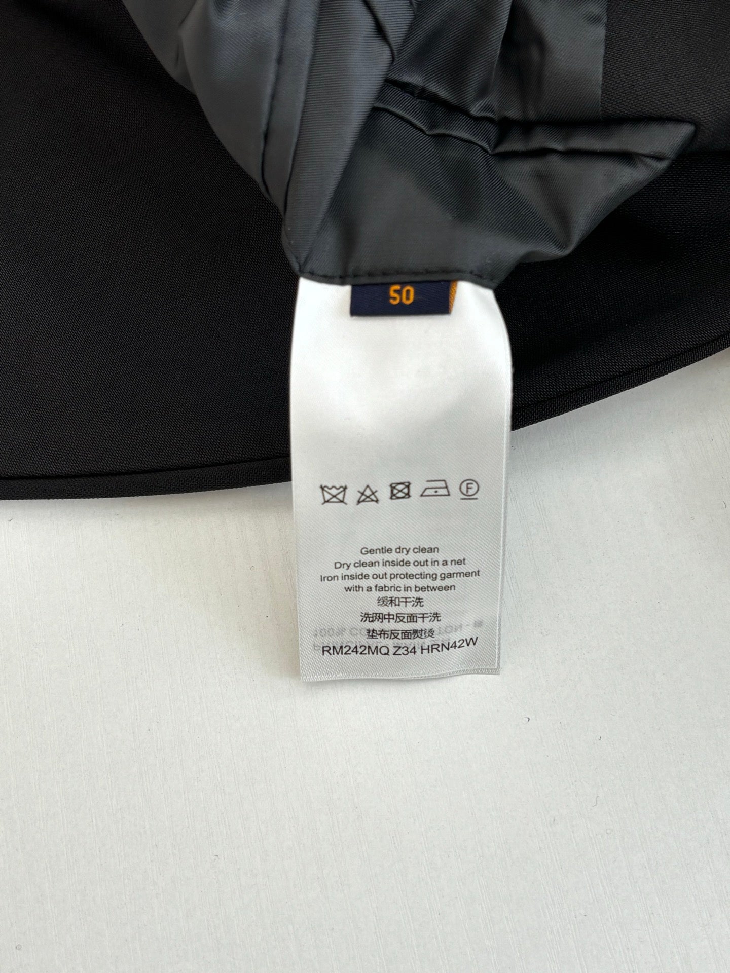 Black trouser care label with size tag inside waistband