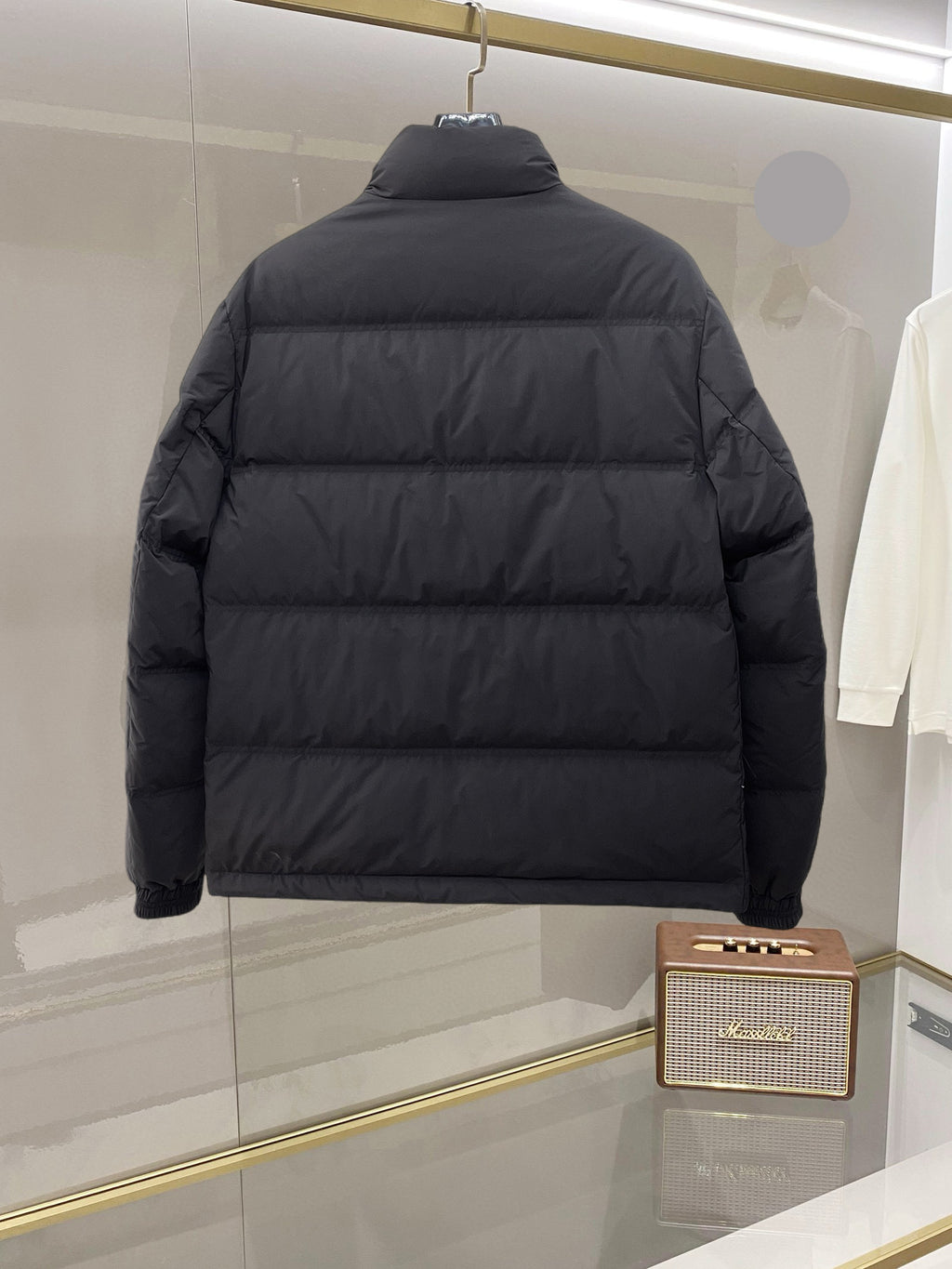 Dark long puffer jacket, back view, full-zip design with quilted panels