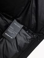 Dark puffer jacket fabric with Prada Milano care tag and drawstring detail