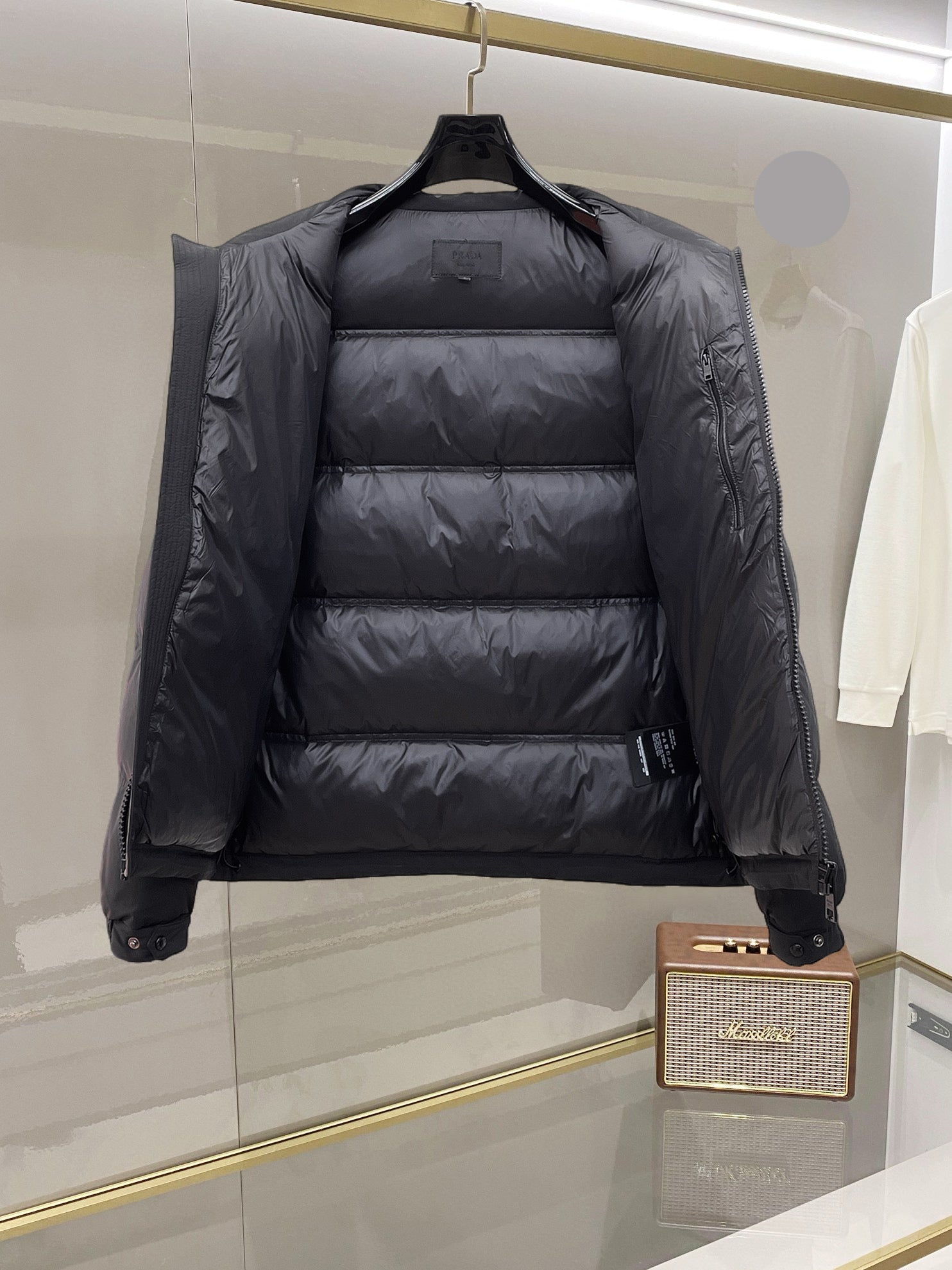 Dark long puffer jacket, front interior view with stand collar and quilted insulation