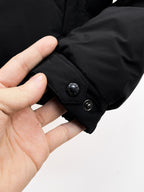 Dark puffer jacket cuff with snap button and ribbed inner trim
