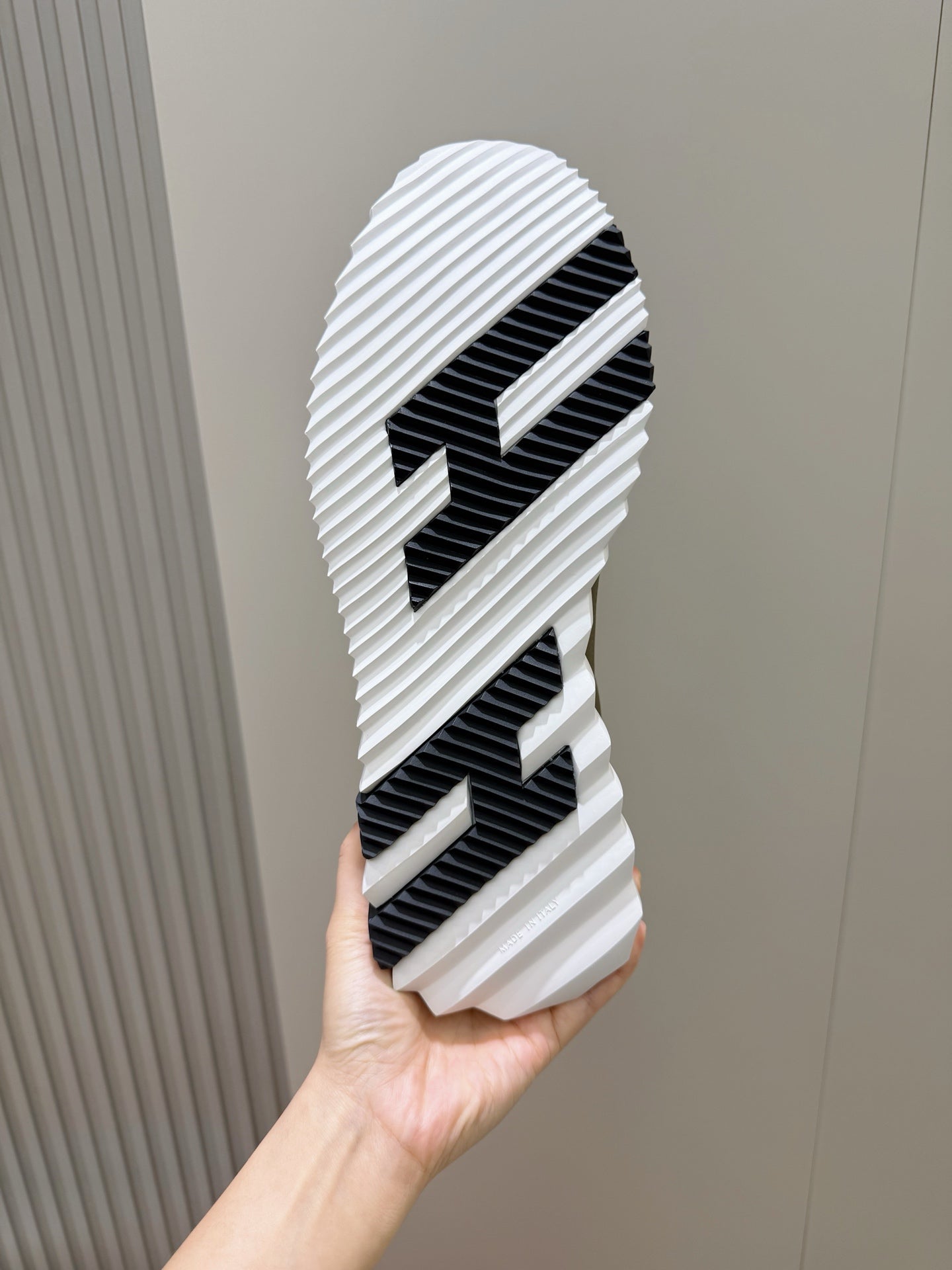 Shoe outsole view: white rubber tread with black striped pattern