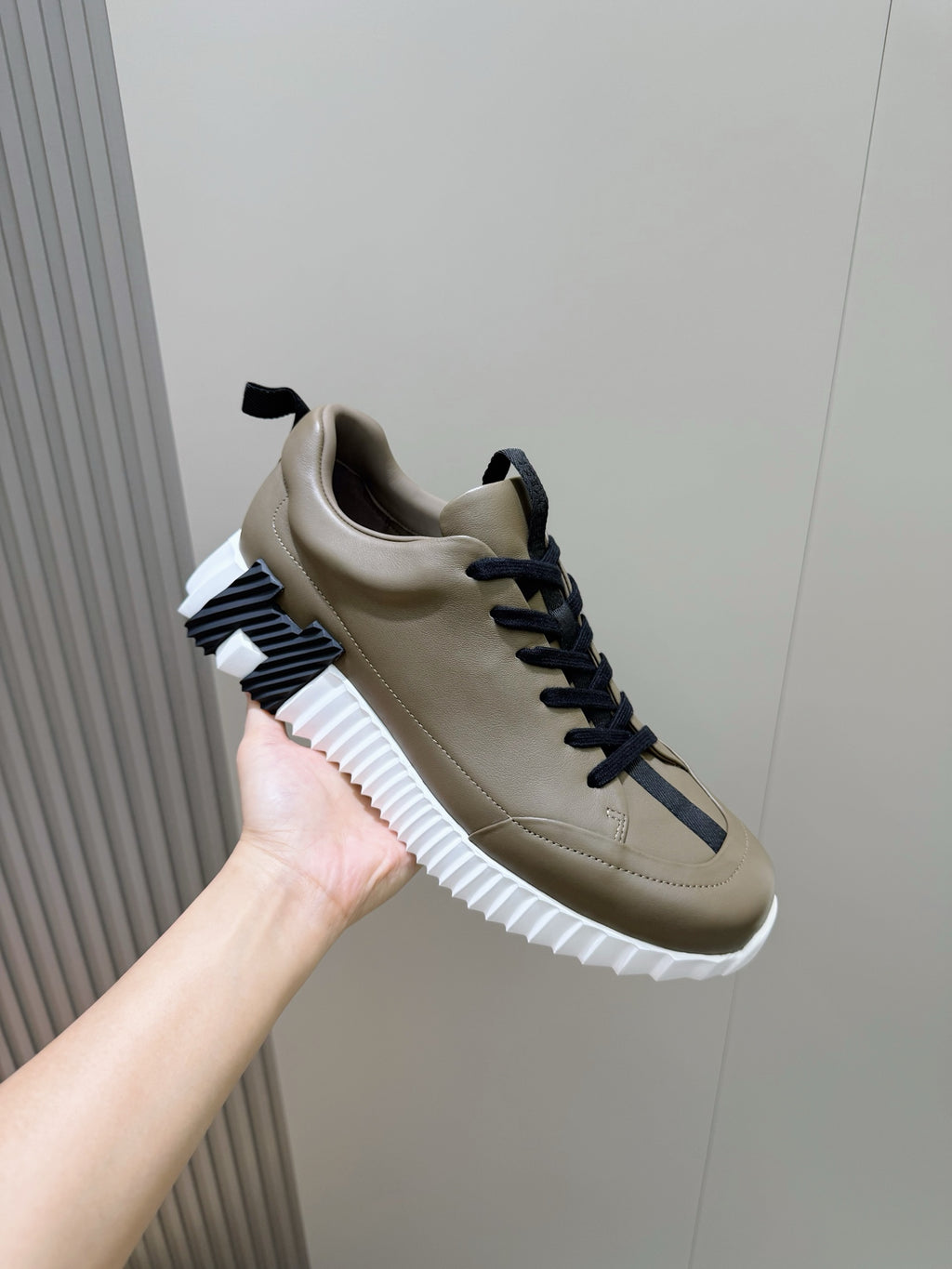 Olive sneaker with navy laces and white ridged sole, side view