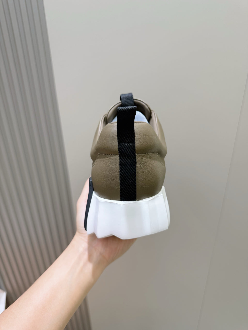 Back view of olive sneakers with navy strap and white chunky sole