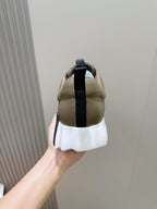 Back view of olive sneakers with navy strap and white chunky sole