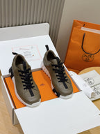 Pair of olive sneakers with navy laces and thick white rubber sole