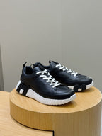 Black lace-up sneakers with white laces and textured platform sole, side view