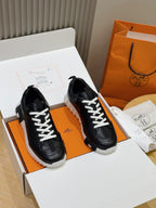 Black lace-up sneakers with white laces and thick ridged sole