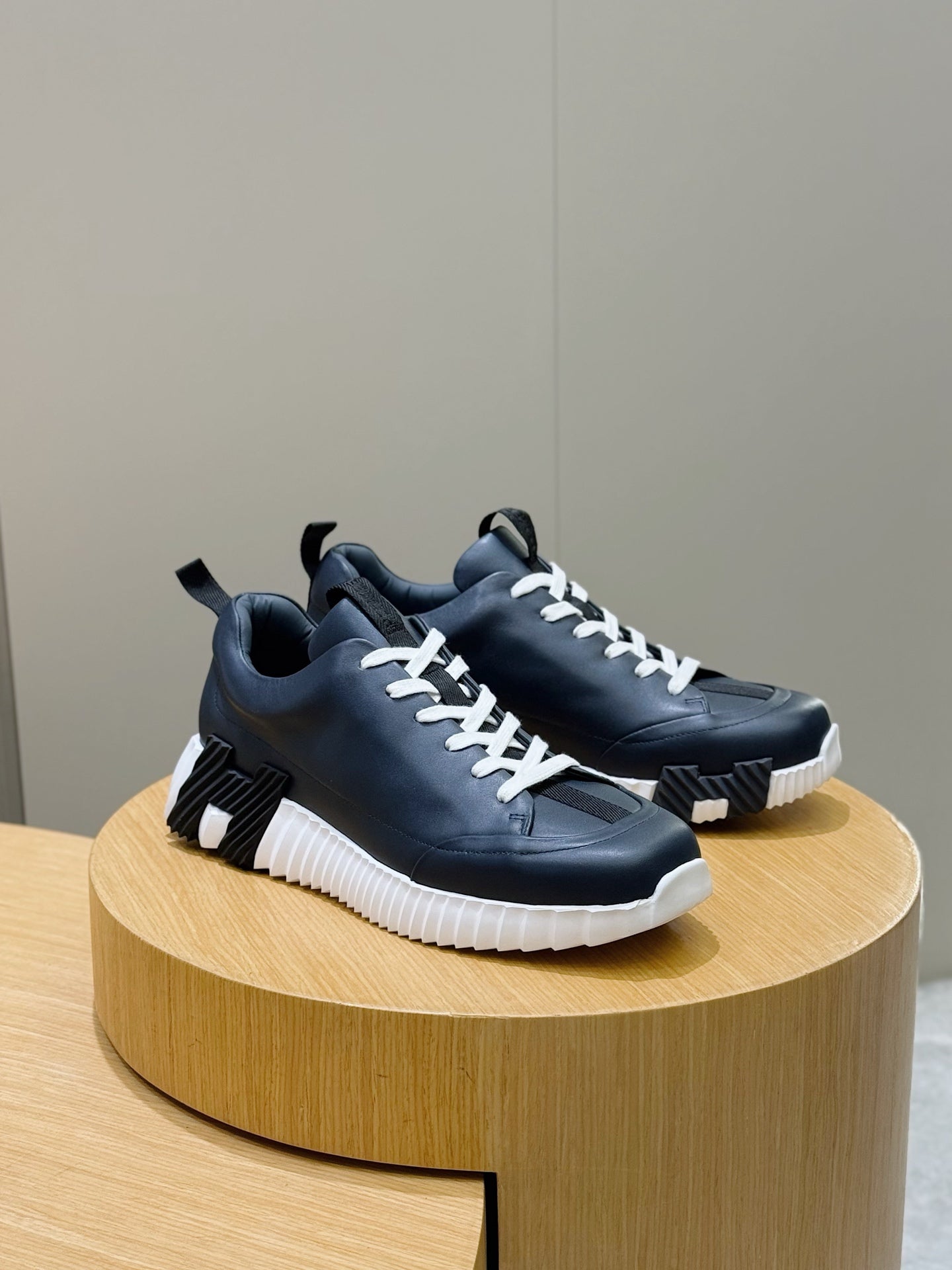 Unisex dark navy sneakers with white laces and textured panels on display