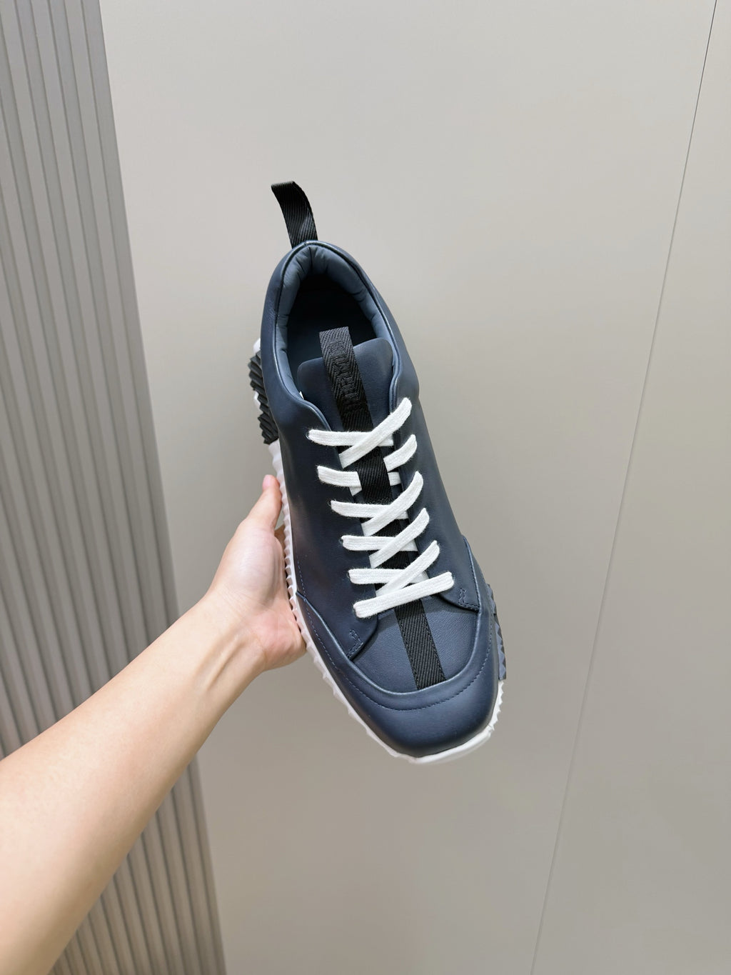 Unisex dark navy sneaker with white lace-up, grippy sole, and pull tab