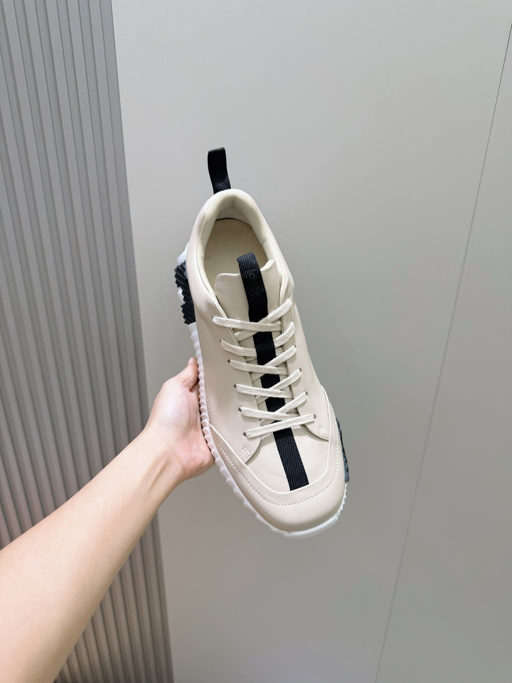 Unisex luxury sneaker by Hermes, cream leather with navy stripe, lace-up front