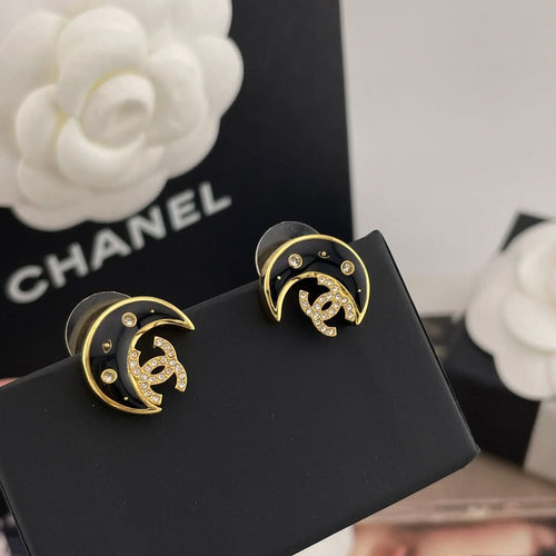 Crescent moon stud earrings with gold-tone border, black enamel, and rhinestones