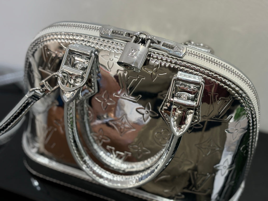 Louis Vuitton monogram handbag front detail with clasp and zip hardware