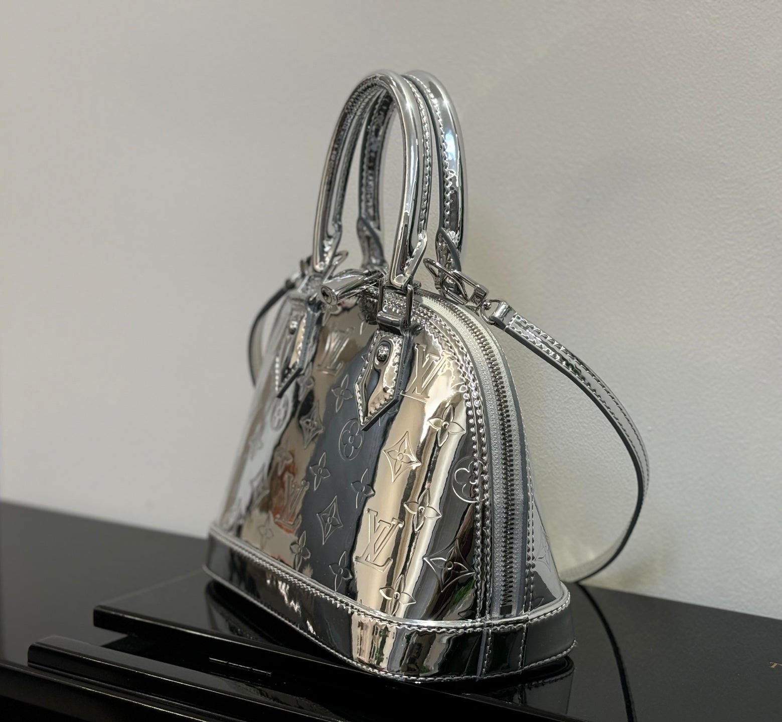 Louis Vuitton monogram handbag angled side view with top handles and zipper trim