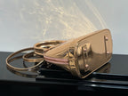Louis Vuitton bag with front gold-tone clasp and top handle, pale pink body, zipper top.