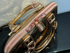 Louis Vuitton bag close-up of top hardware and chain strap, pink zipper, gold accents.