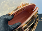 Louis Vuitton bag interior view with red-brown lining and pink zipper trim, gold zipper edges.