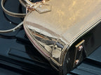 Louis Vuitton bag detail with gold embossed monogram, pink edging, and front corner hardware.