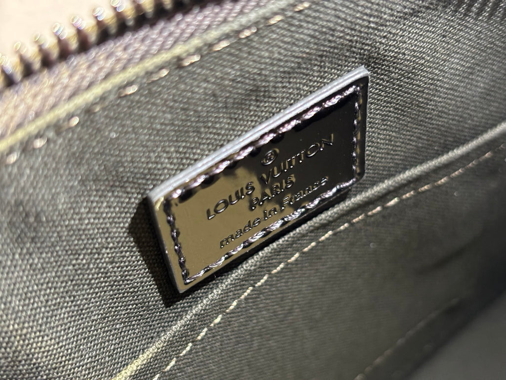 Louis Vuitton logo plaque on metallic silver handbag with zipper trim and stitching