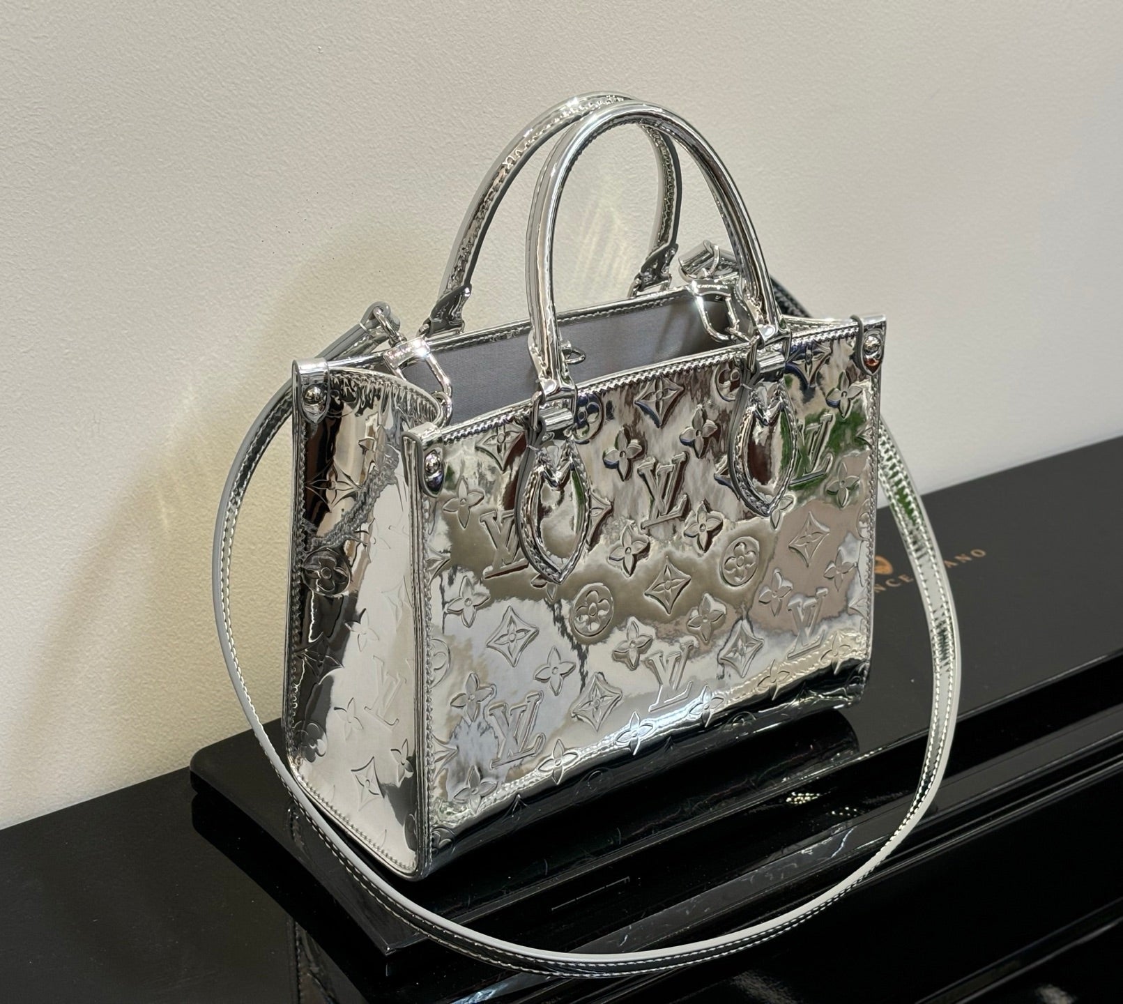 Louis Vuitton monogram tote bag with top handles, metallic silver sheen and embossed motifs