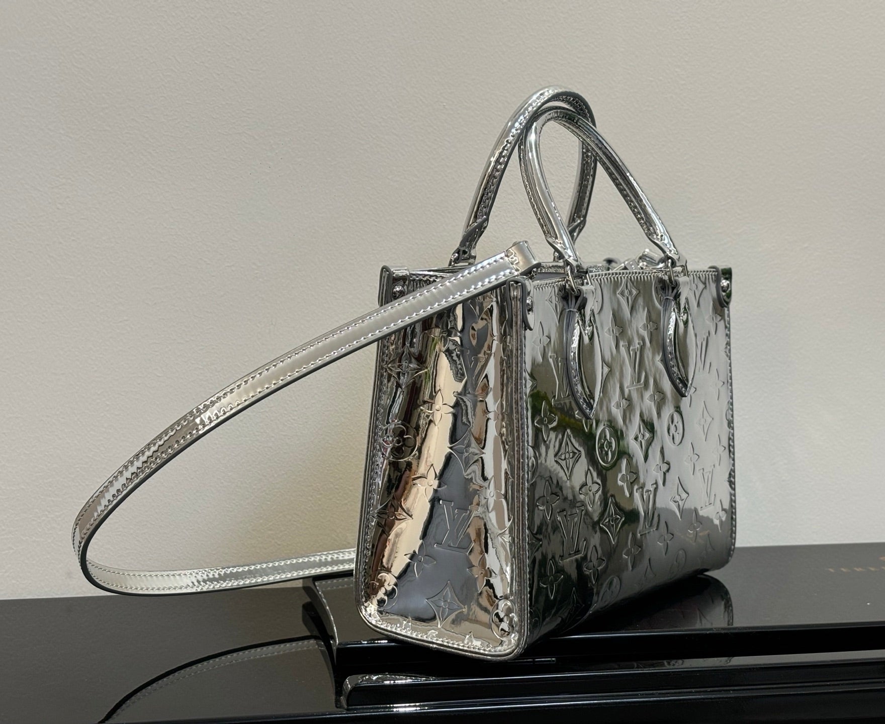 Louis Vuitton monogram tote bag with top handles and long shoulder strap, metallic finish