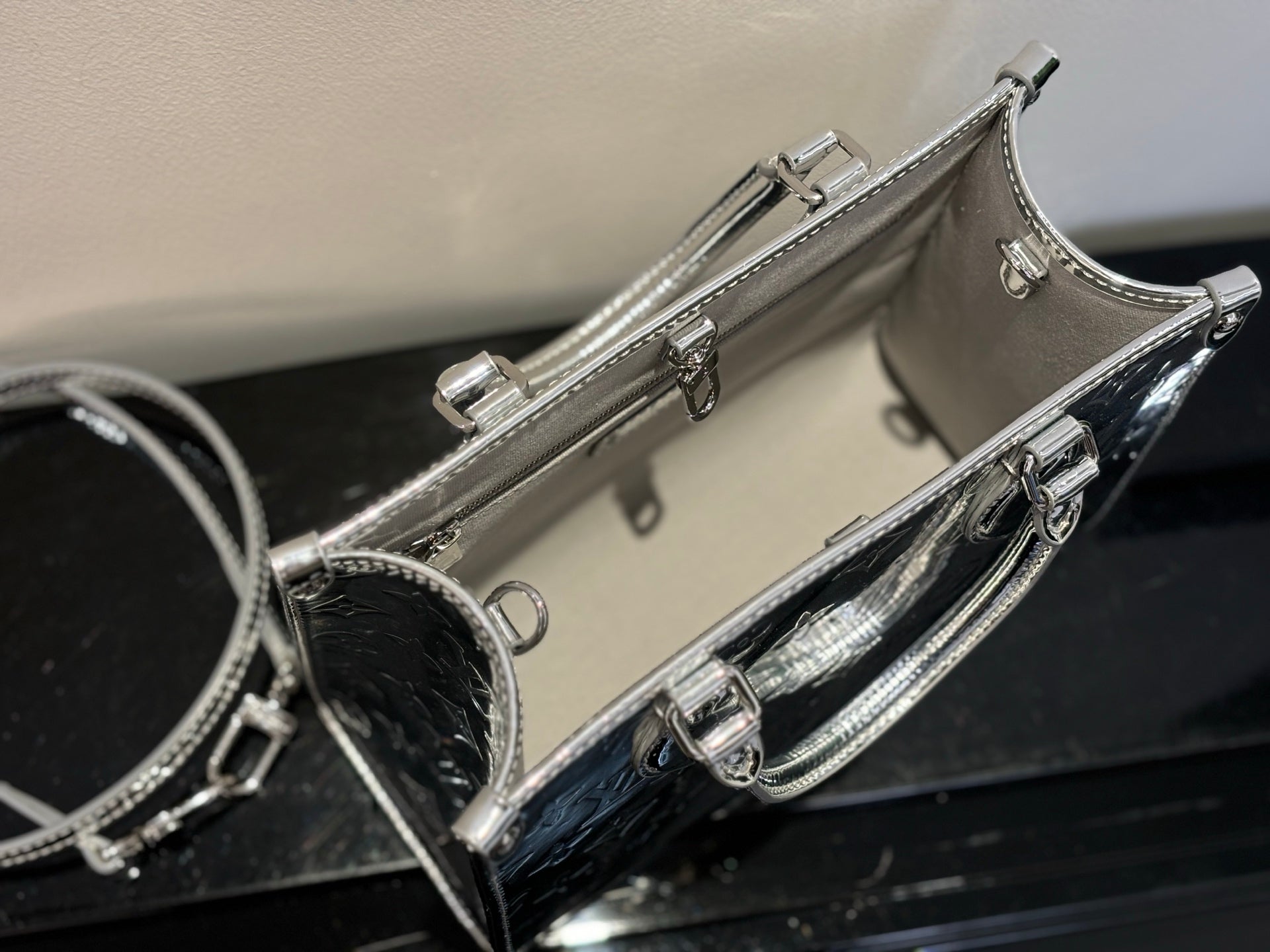 Louis Vuitton monogram handbag with zip closure and top handle, metallic silver and black trim