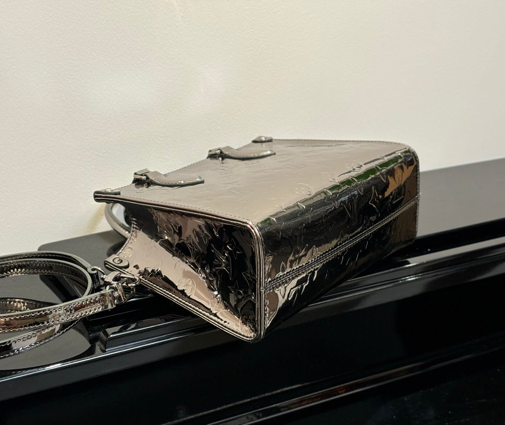 Louis Vuitton handbag top view, glossy metallic finish with hardware and structured rectangular shape